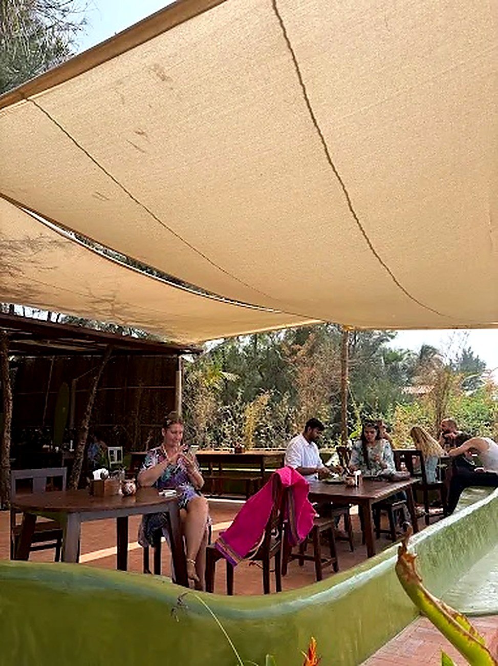 Guests eating under the shade sail in the garden